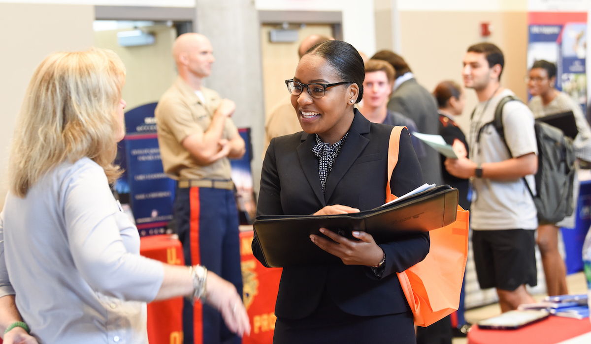 Female student talking to a potential employer at a CUA career fair